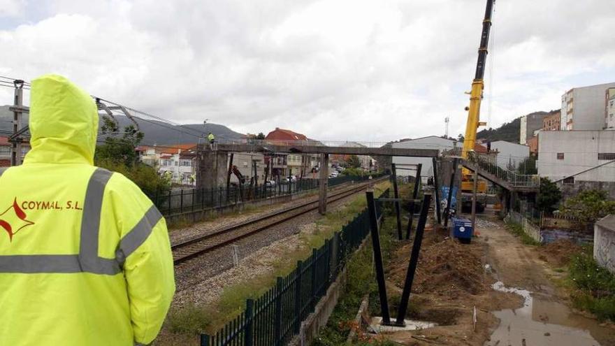 Una grúa de grandes dimensiones se prepara para levantar la antigua pasarela del tren. // Marcos Canosa