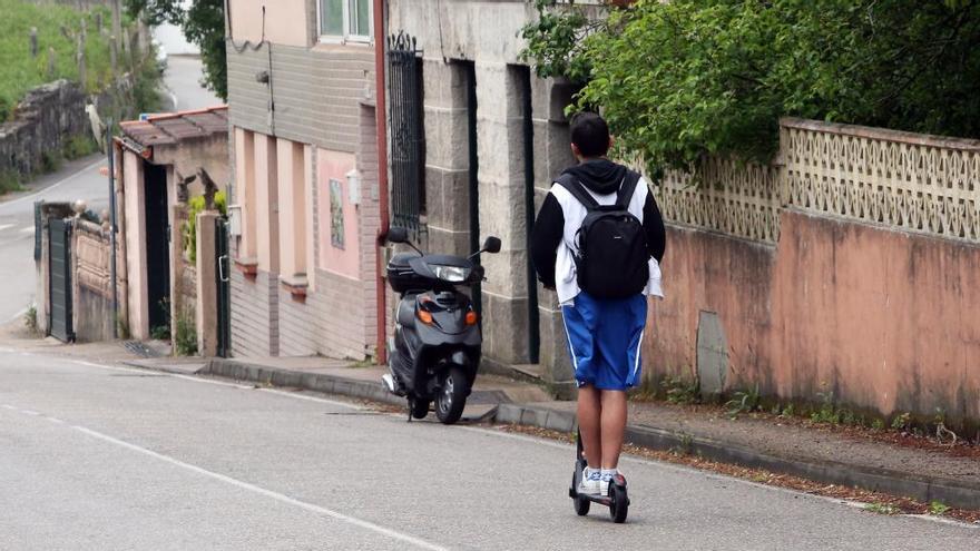 Un joven circula en patinete por una calle de Vigo. / Marta G. Brea