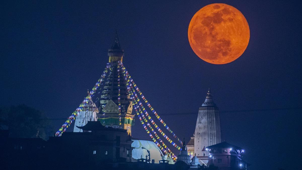 La superluna rosa se alza sobre Swayambhunath, el antiguo complejo religioso del valle de Katmandú, este martes.