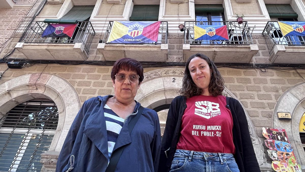 Rosa y Lucía, frente al edificio en el que viven, con las banderas del Poble-sec en los balcones