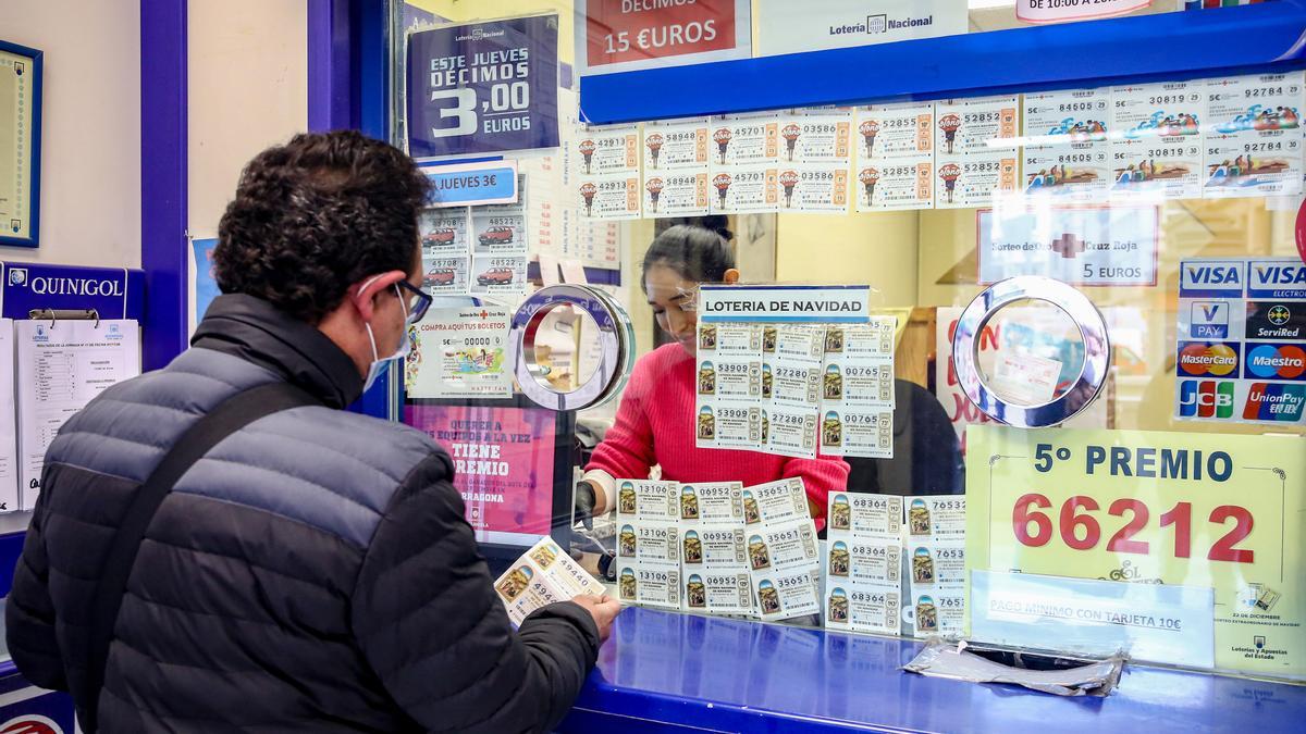 Una persona compra un décimo de la Lotería de Navidad.