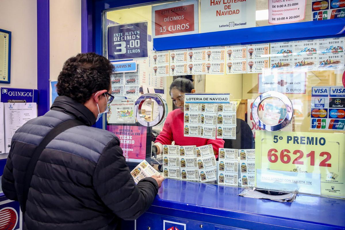 Una persona compra un décimo de la Lotería de Navidad.