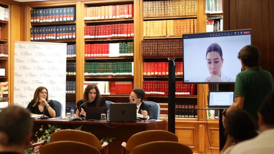 Paz Fernández-Rivera, Montserrat Díaz Marí, Luis Nogueiro, Irene Aguiar (en la pantalla) y Ernesto Tuñón (de espaldas), en la biblioteca del Colegio de Abogados de Oviedo. | Zai Semeyes