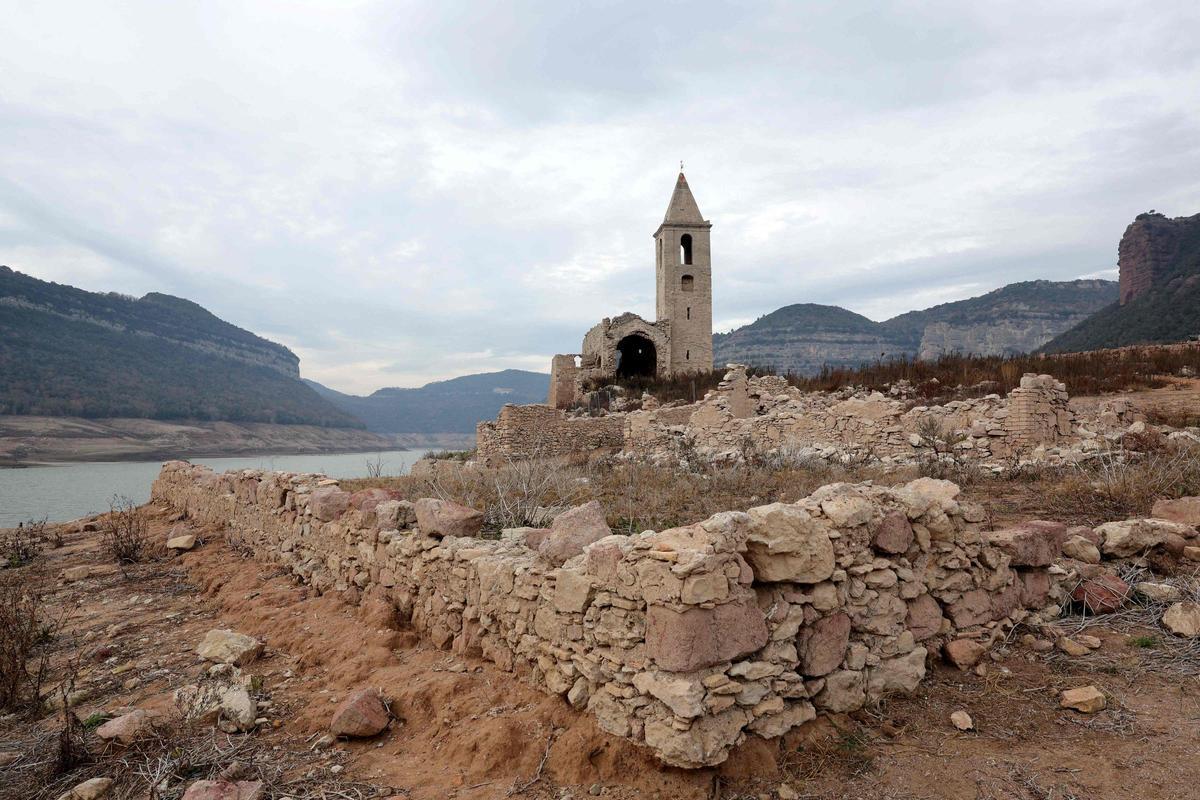 Esta fotografía tomada el 15 de enero de 2024 muestra la iglesia de Sant Roma de Sau en la orilla del estiaje del embalse de Sau, situado en la provincia de Girona en Cataluña. Cataluña lucha contra una sequía histórica desde hace tres años y algunos residentes ya experimentan restricciones de agua en su vida diaria.