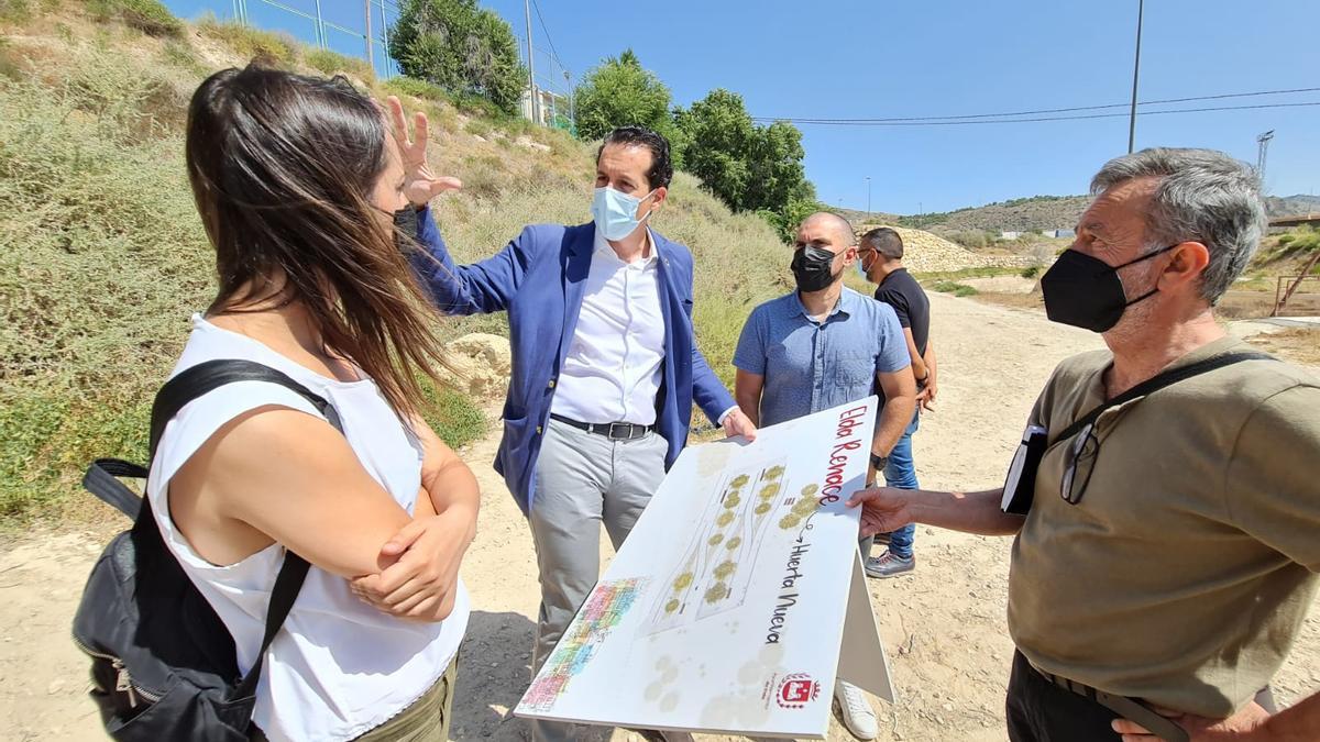 El alcalde, el concejal y los técnicos en los terrenos donde se construirá la nueva rampa que comunicará el barrio Huerta Nueva con los jardines del PERI del Vinalopó.