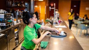 Una camarera de un bar atiende la barra, en una imagen de archivo.