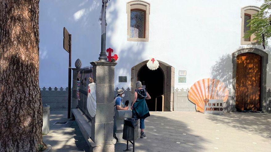 Una pareja de peregrinos a las puertas de la iglesia de San Bartolomé en Tunte.