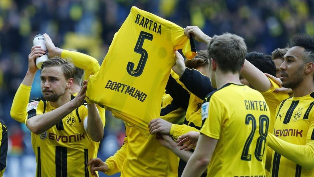 Los jugadores del Dortmund muestran una camiseta de Bartra mientras celebran el triunfo ante el Eintracht de Fráncfort, este sábado en Iduna Park.