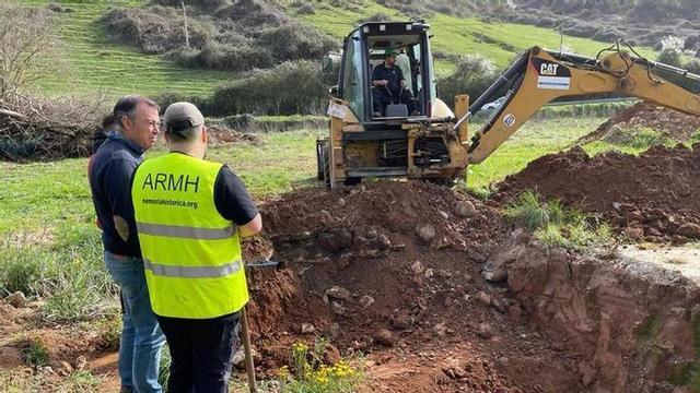 El alcalde de Grado, José Luis Trabanco, conversa con uno de los arqueólogos junto a la fosa.