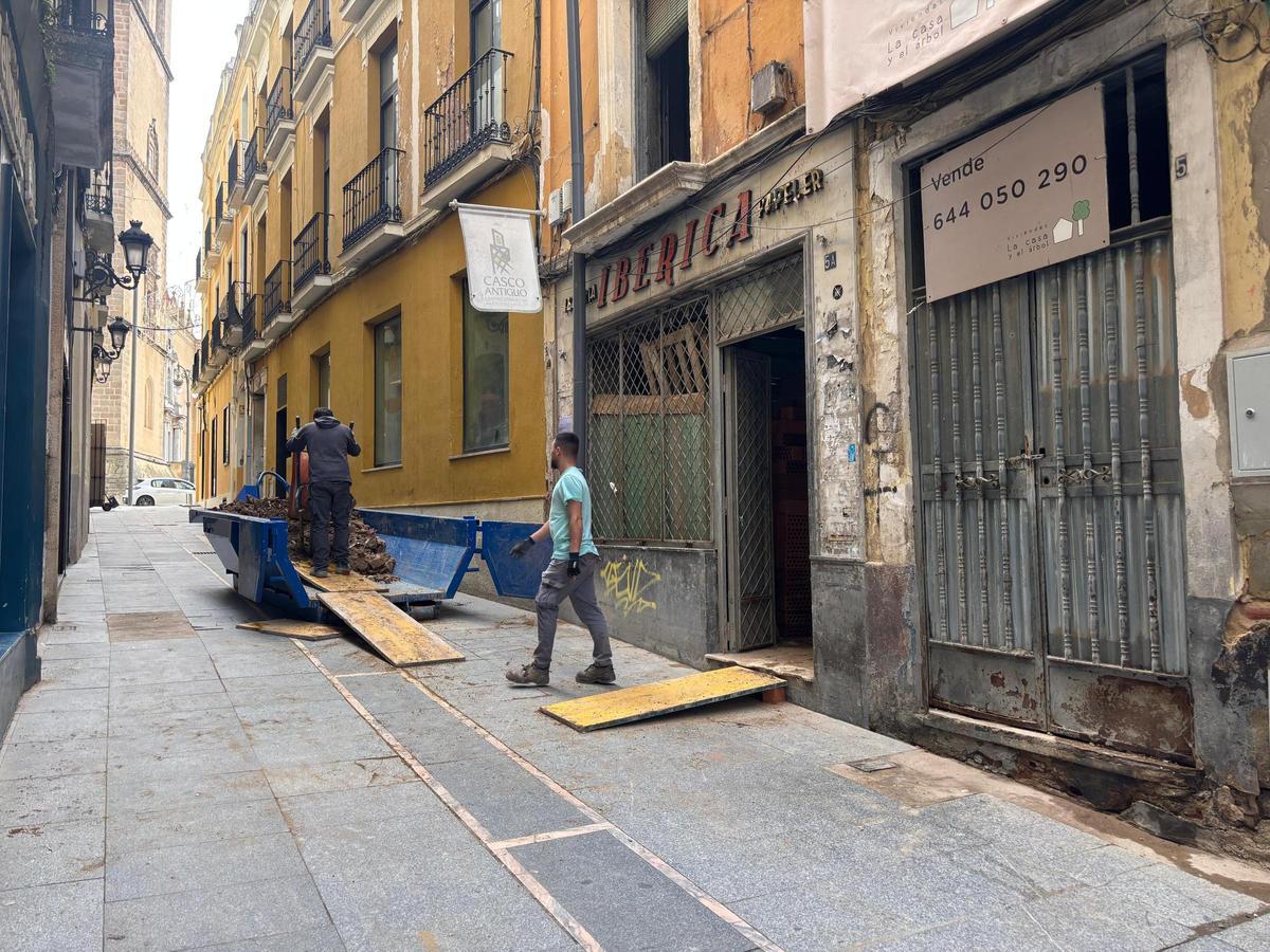 Dos obreros salen de la mítica Librería Ibérica que la empresa La Casa y el Árbol está rehabilitando en la calle Meléndez Valdés de Badajoz.