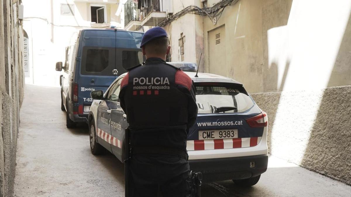 Un agent dels Mossos d'Esquadra al carrer del barri vell on s'ha escorcollat un pis