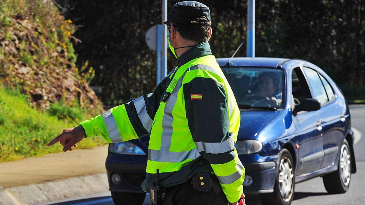 Un agente de la Guardia Civil ordena detenerse a un vehículo.