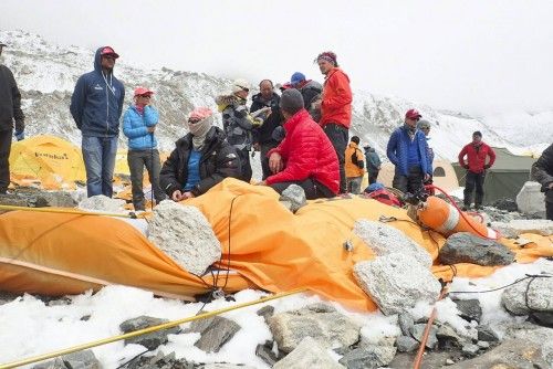 Escaladores descansan junto a los restos del campamento base en el Monte Everest