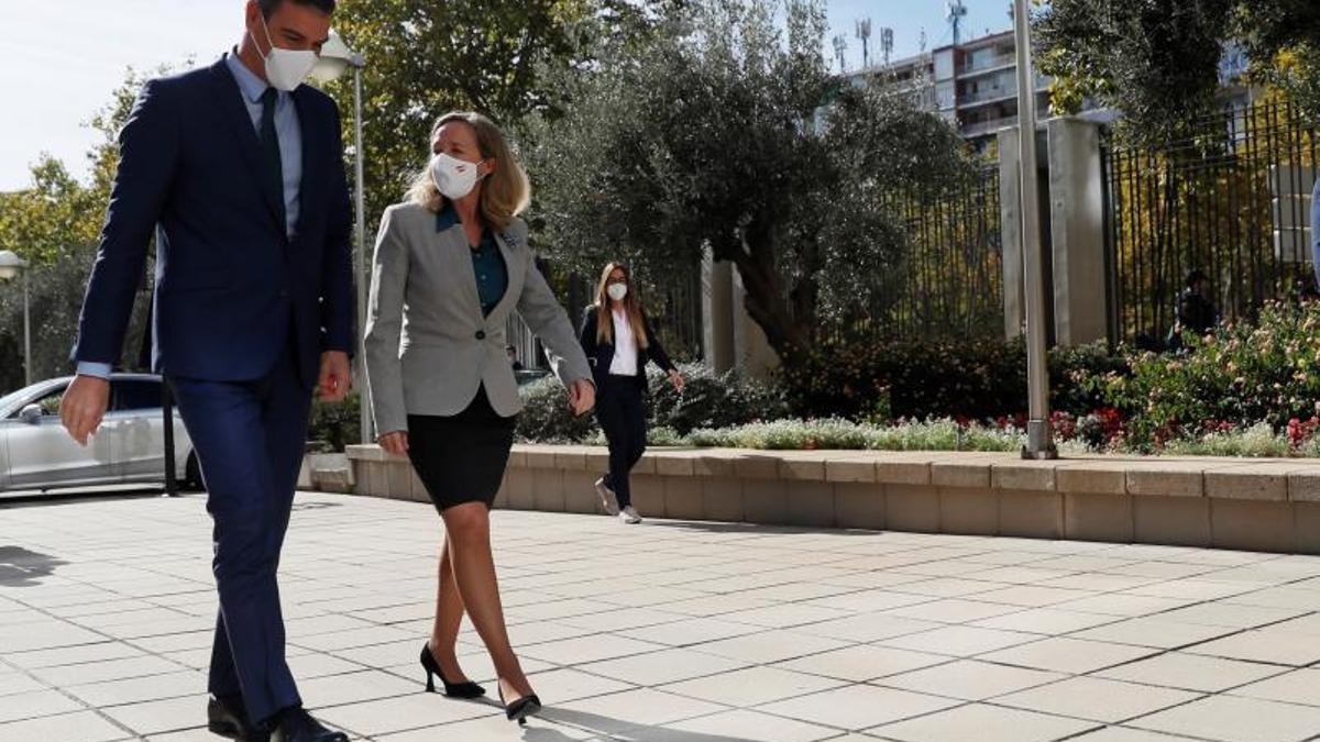 El presidente del Gobierno, Pedro Sánchez, junto a la vicepresidenta primera y ministra de Asuntos Económicos y Transformación Digital, Nadia Calviño, a su llegada a la clausura del seminario 'Monitoring the recovery: beyond GDP', este 25 de octubre de 2021, en Madrid.