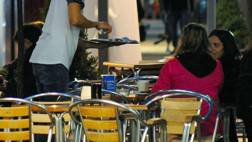 Un camarero atiende a los clientes de una de las terrazas de la calle Rey Daviña, en Vilagarcía. // Iñaki Abella