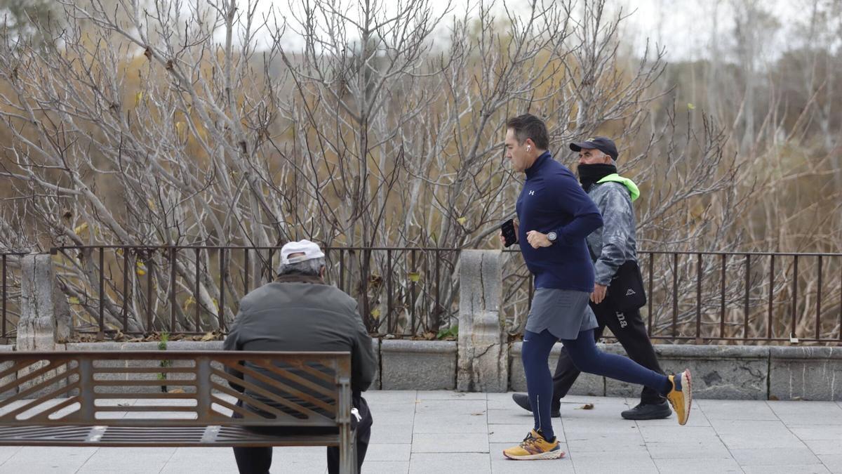 Varias personas hacen deporte por la ribera de Córdoba en una mañana de ambiente frío.