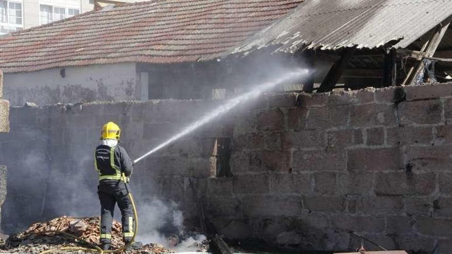 Un bombero refrescando el astillero de Calragho. // Santos Álvarez