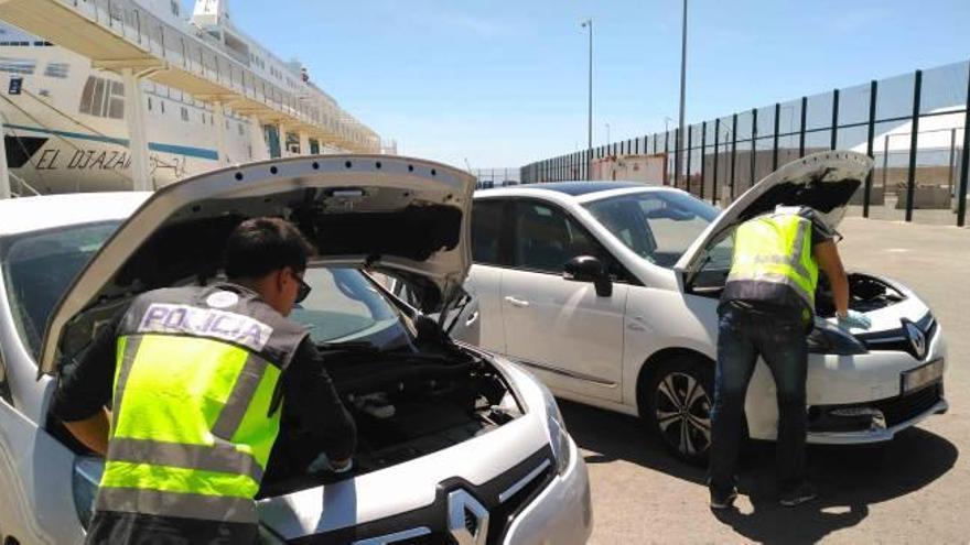 Dos agentes revisan los coches robados que iban a llevar a Argelia.