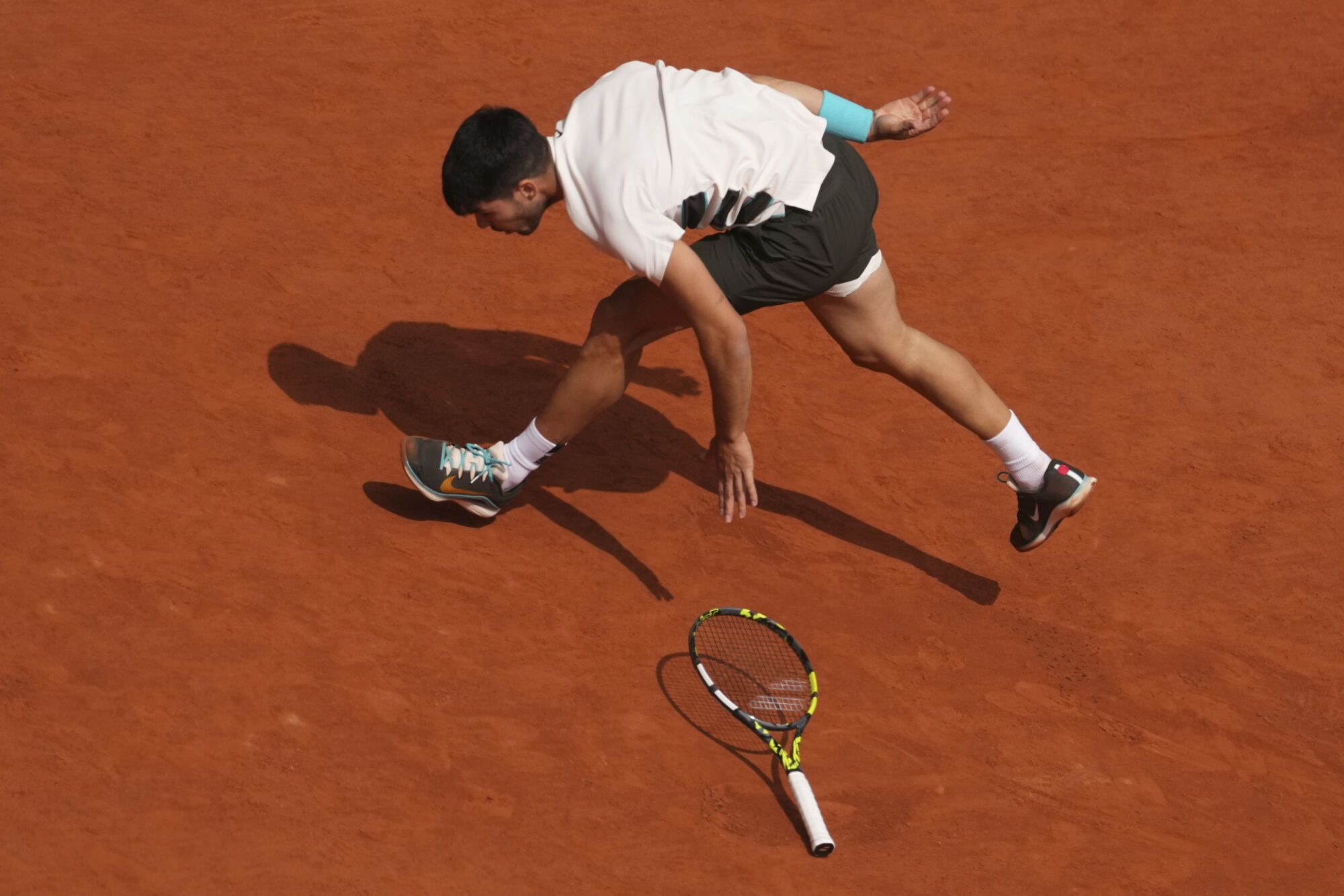 Spain's Carlos Alcaraz drops his racket as he plays against Italy's Jannik Sinner during their final match of the French Tennis Open at the Roland-Garros stadium in Paris, Sunday, June 8, 2025. (AP Photo/Thibault Camus). EDITORIAL USE ONLY/ONLY ITALY AND SPAIN