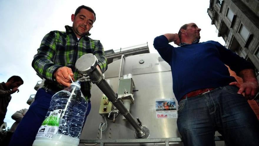 Un ganadero llena una garrafa de agua en la Praza de Galicia. Iñaki Abella