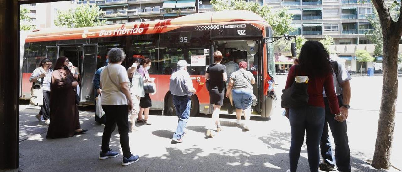 Varios usuarios esperan a la sombra a poder subir al autobús.