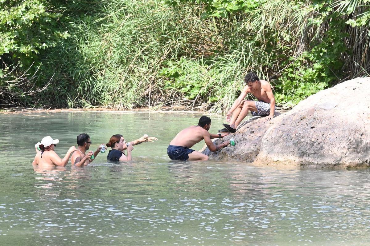 Unos ciudadanos disfrutan de las aguas tranquilas del Millars en la playa fluvial del Termet d Vila-real.