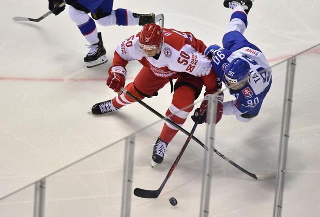 El delantero de Dinamarca Mathias Bau (L) y el delantero de Eslovaquia Tomas Tatar compiten por el disco durante el partido del Grupo A del Campeonato Mundial de Hockey sobre hielo masculino IIHF entre Eslovaquia y Dinamarca en Kosice.