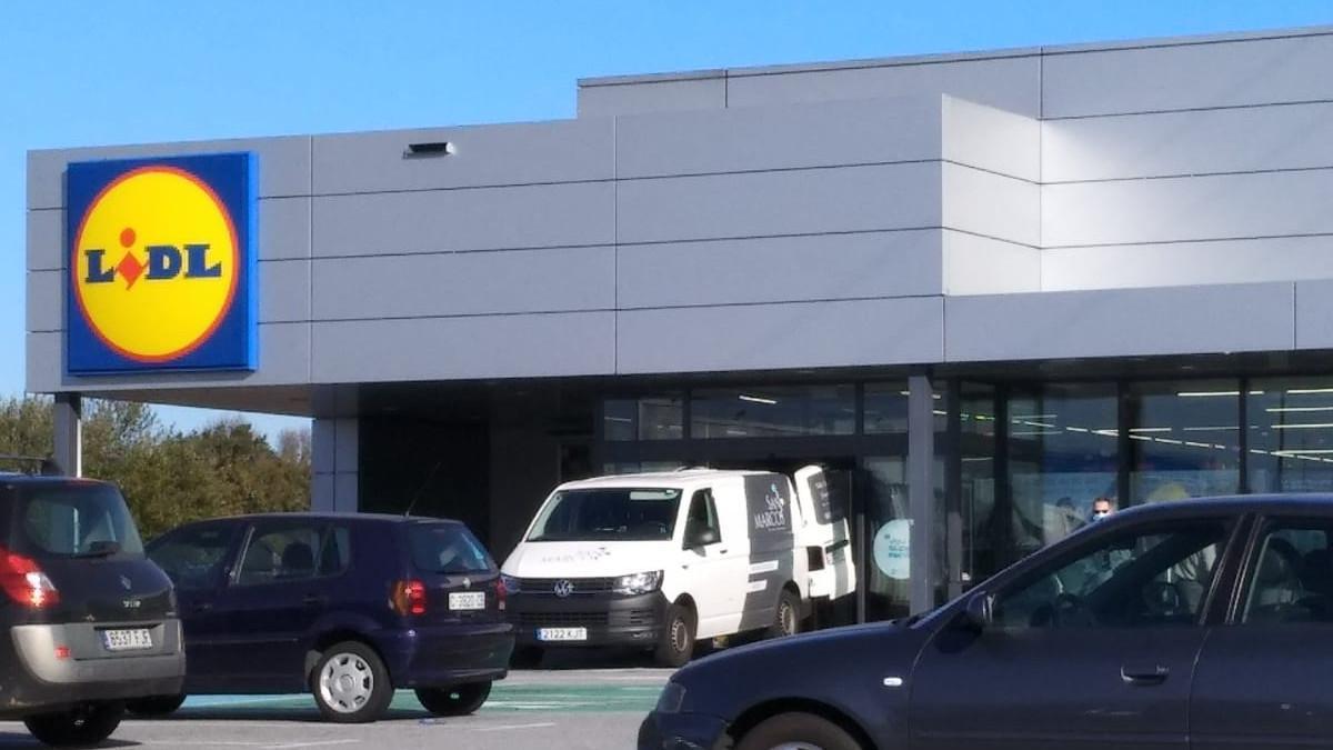 El vehiculo de la funeraria en la puerta del supermercado, esta mañana.