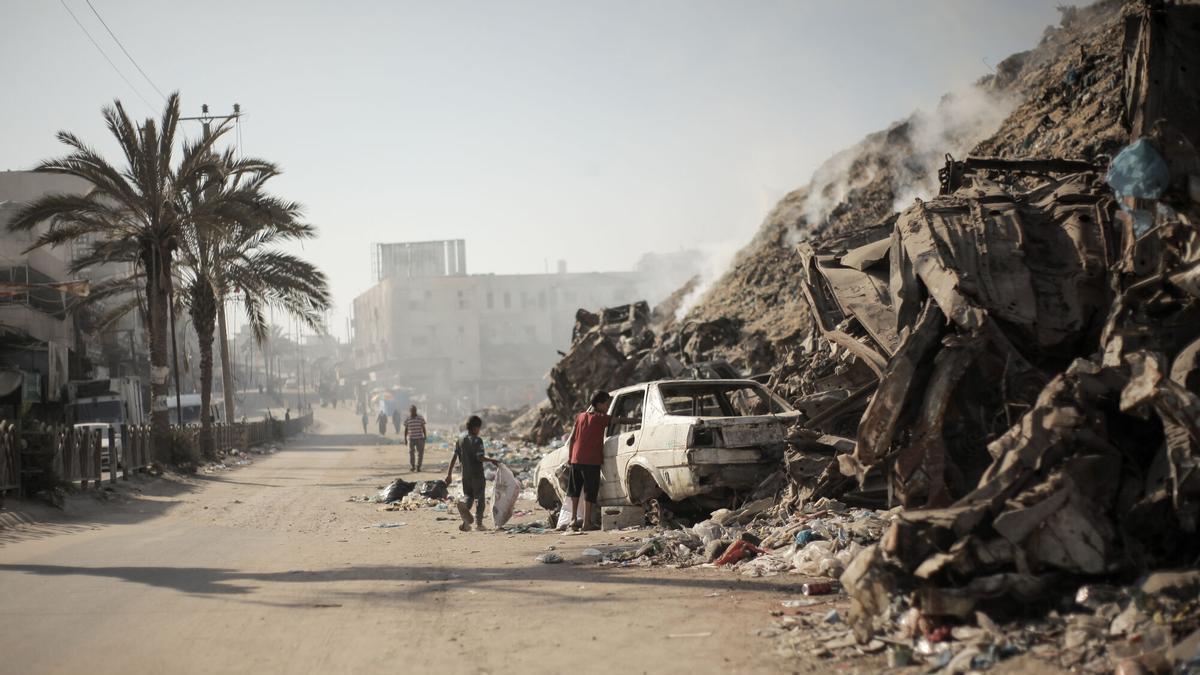 Un vehículo destrozado junto a una montaña de escombros, en la Ciudad de Gaza.