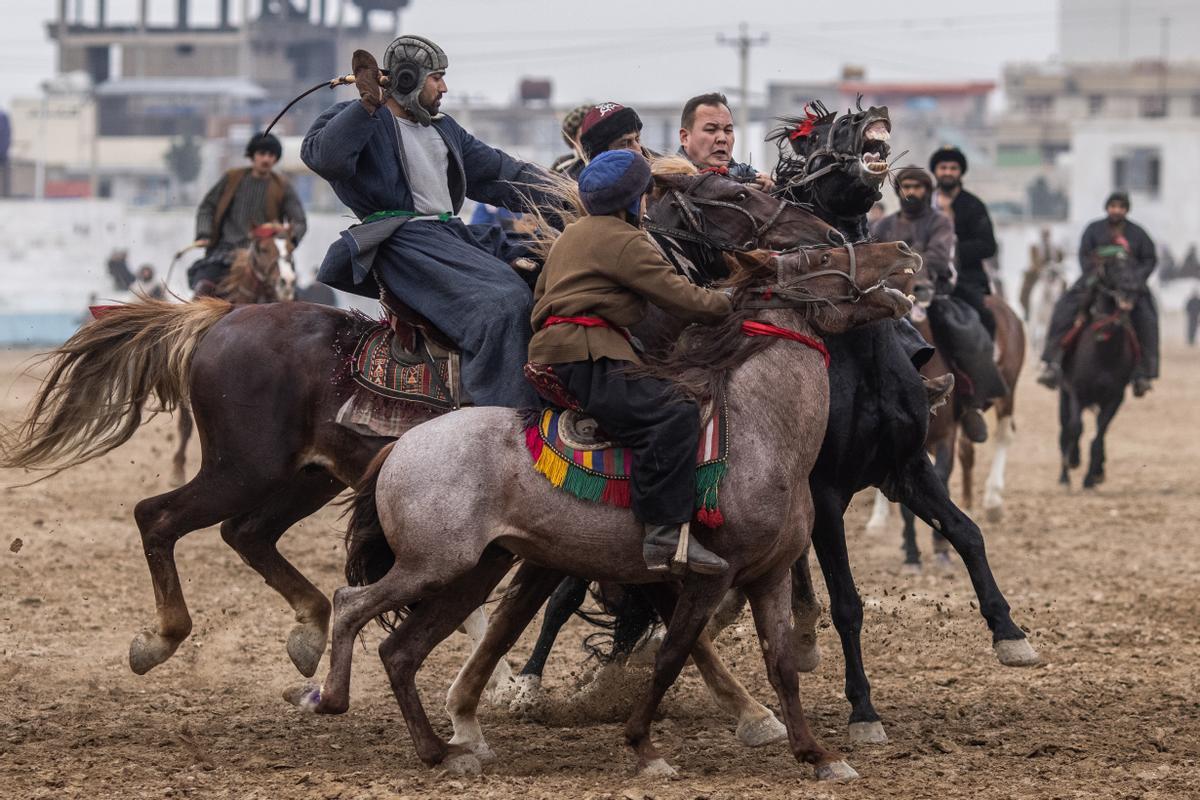 Jinetes afganos compiten en un deporte tradicional de Asia Central, en el que los jugadores montados a caballo intentan colocar una bolsa que se asemeja a un cadáver de cabra en una portería