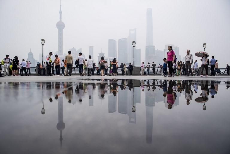 Los turistas acuden en masa al paseo en el Bund a lo largo del río Huangpu / AFP PHOTO / Johannes EISELE