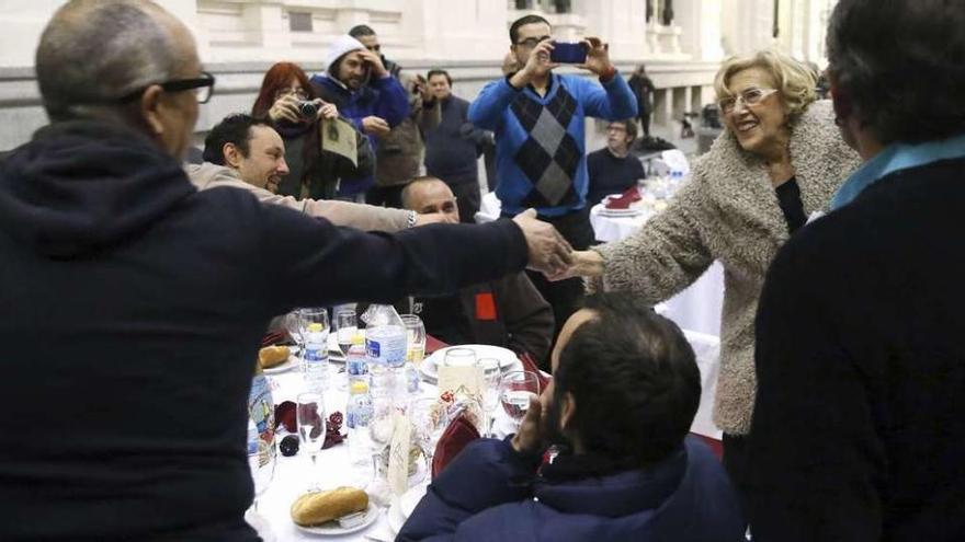 La alcaldesa Manuela Carmena saluda a los sin techo antes de la cena.