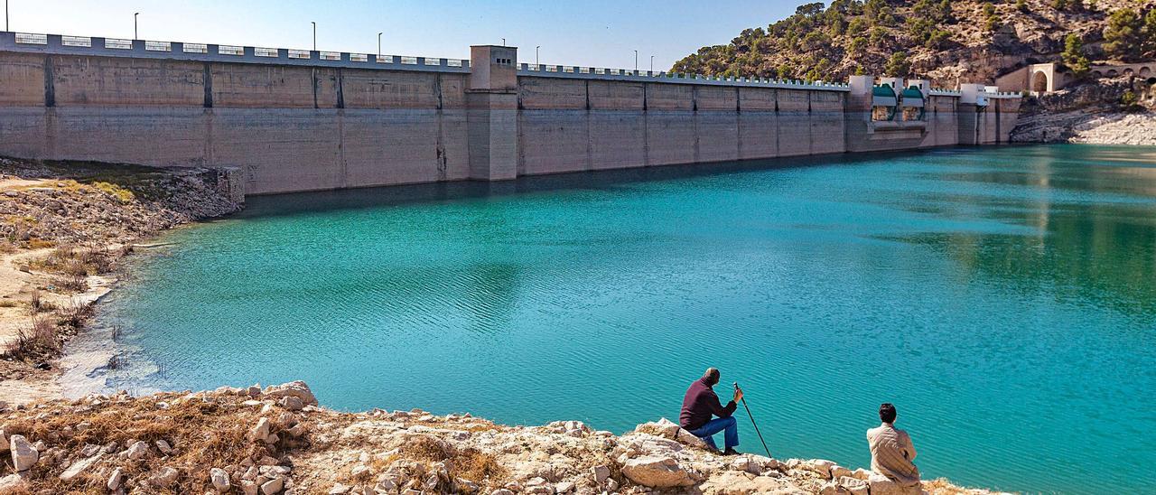 Una pareja de excursionistas observa la lámina de agua del embalse del Amadorio, que está al 44% de su capacidad tras un invierno muy seco. | DAVID REVENGA