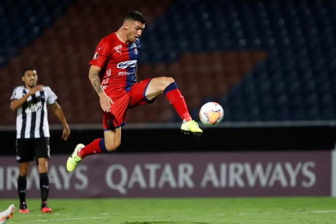 El jugador Carlos Monges del Deportivo Independiente Medellín patea hoy el balón para anotar el cuarto gol de su equipo contra Libertad durante un partido por el Grupo H de la Copa Libertadores 2020, en el estadio General Pablo Rojas en Asunción (Pa