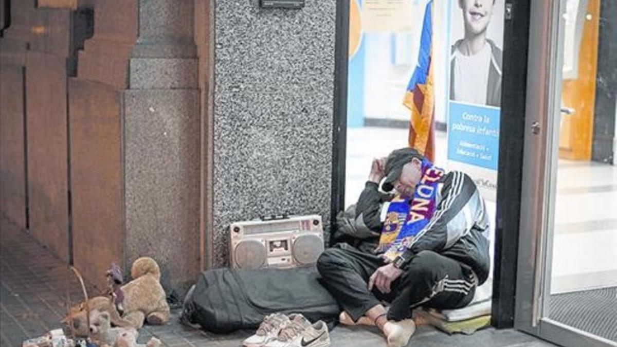 Un hombre duerme frente a un cajero del paseo de Sant Joan, el pasado martes por la noche.