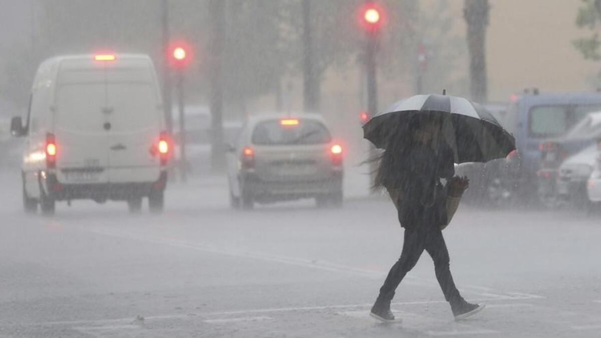 Una imagen de archivo de una joven caminando bajo la lluvia.