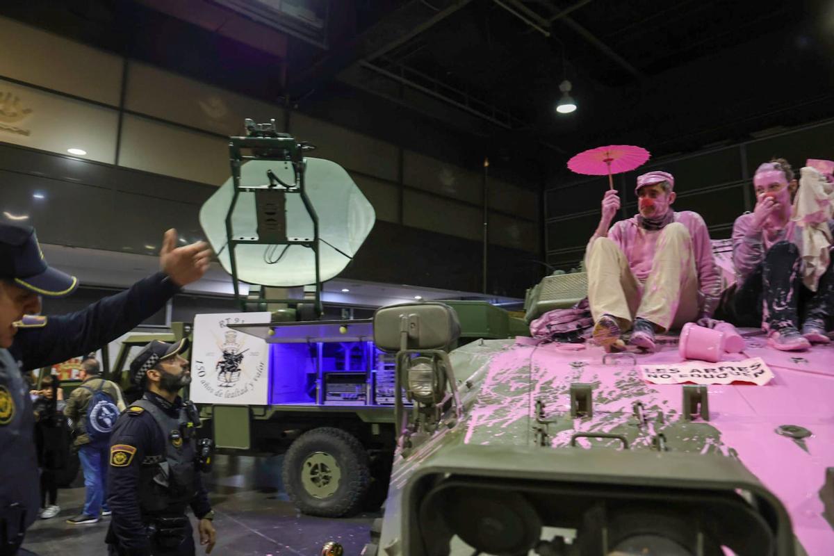 Unos pacifistas rocían pintura rosa sobre una tanqueta en Expojove: "Las armas no educan"