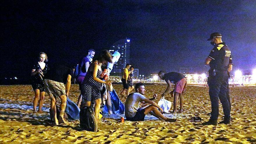 Un grup de persones fent «botellón» a la platja de la Barceloneta.