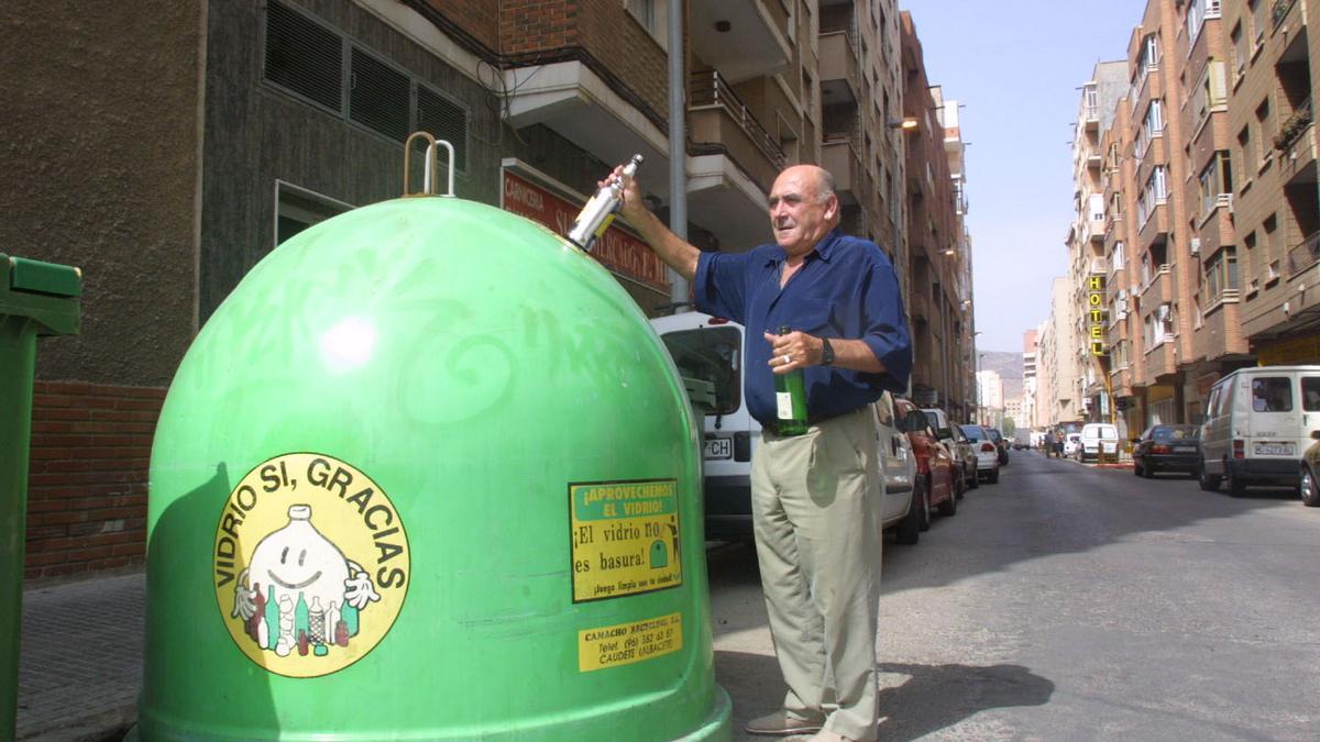 Un ciudadano recicla varios envases de vidrio