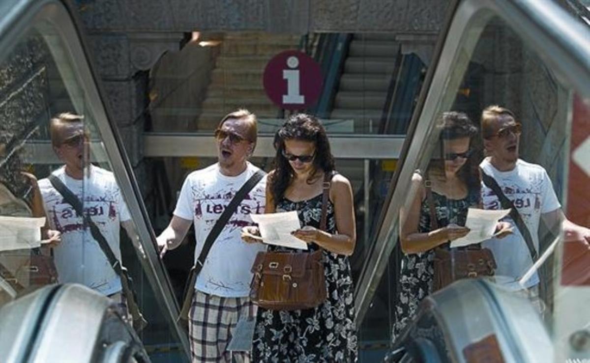 Unos visitantes salen de la oficina de información turística de plaza de Catalunya, ayer.