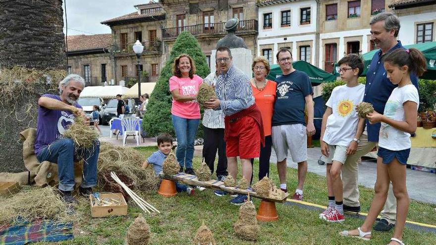 El artesano Luis Díaz Prida y Emilia de Agustín de Miguel, con usuarios de &quot;Raitana&quot; y asistentes al mercado (familia Mauriño), viendo el trabajo del primero, en Villaviciosa.