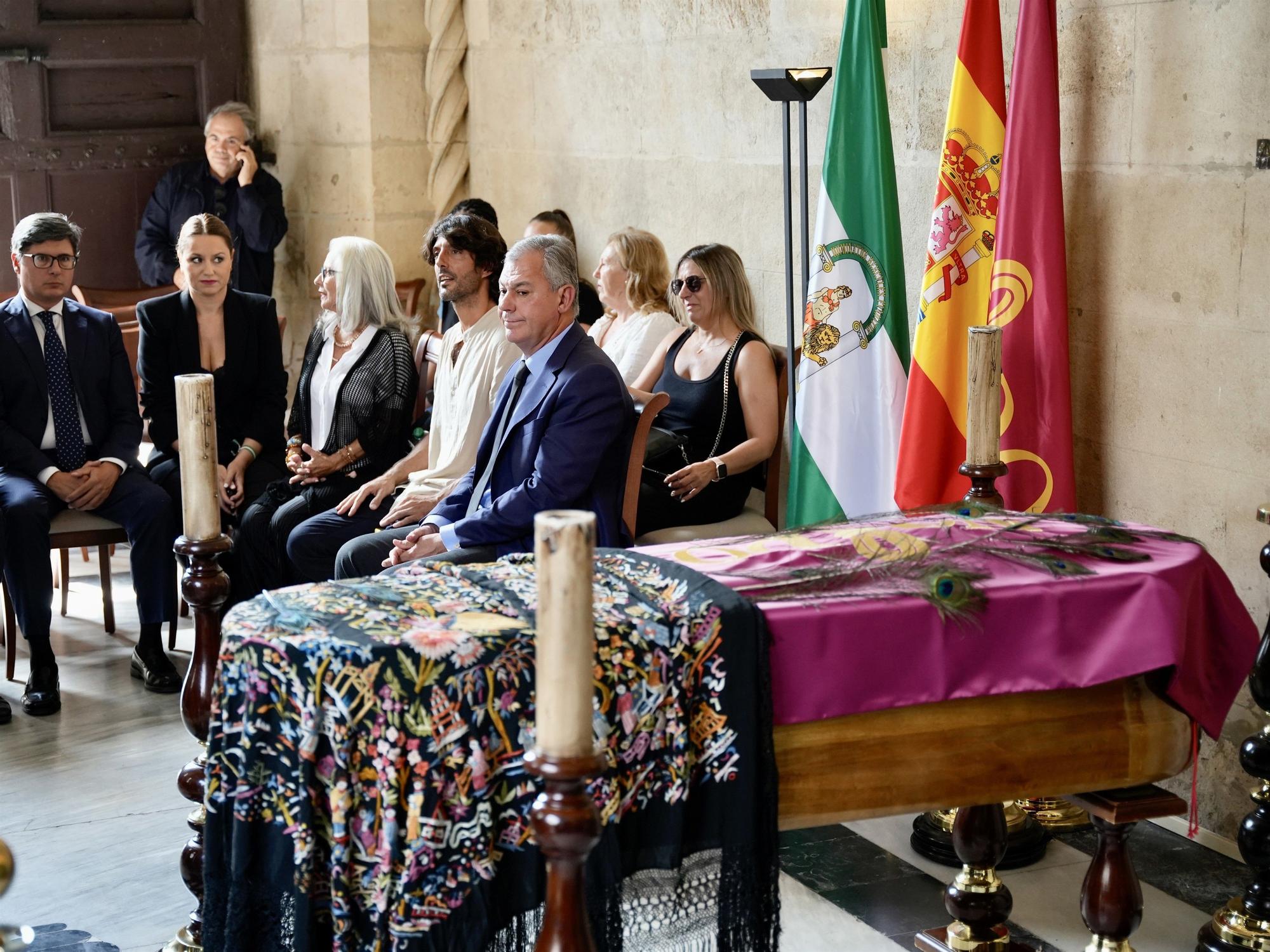 El hijo de María Jiménez, Alejandro Jiménez, su hermana Isabel Jiménez, y el alcalde de Sevilla, José Luis Sanz; junto al féretro de la artista instalado ya en la Capilla Ardiente en el Ayuntamiento de Sevilla