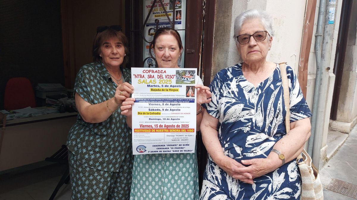 Milagros Pérez, María Teresa Aparicio y Orfelina García posan en el local de la Crofadía con un cartel de los festejos.