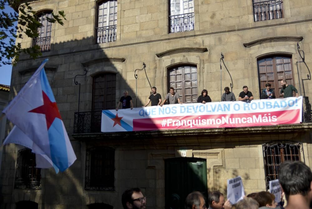 Despliegan una pancarta con el lema 'Que nos devolvan o roubado' en el inmueble de la calle Damas para denunciar los "privilegios" de la familia del dictador.