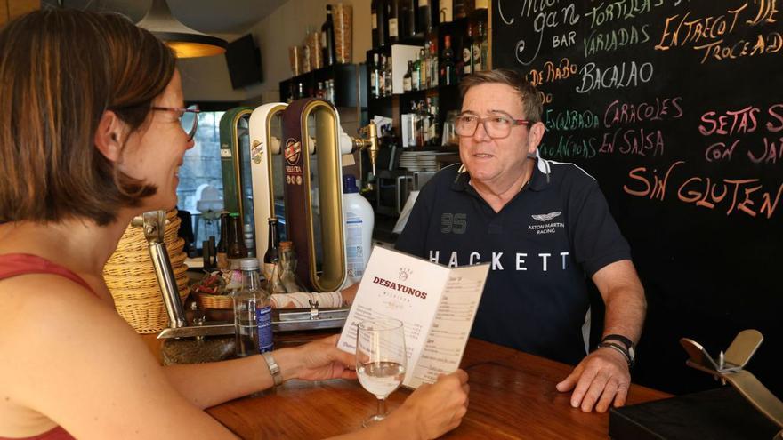 Víctor Castillo, atiende a Azul Forti, la vecina celíaca que promovió la campaña de sensibilización en la hostelería, en el Bar Michigan, el único sin gluten acreditado de Nigrán. |   // JOSE LORES