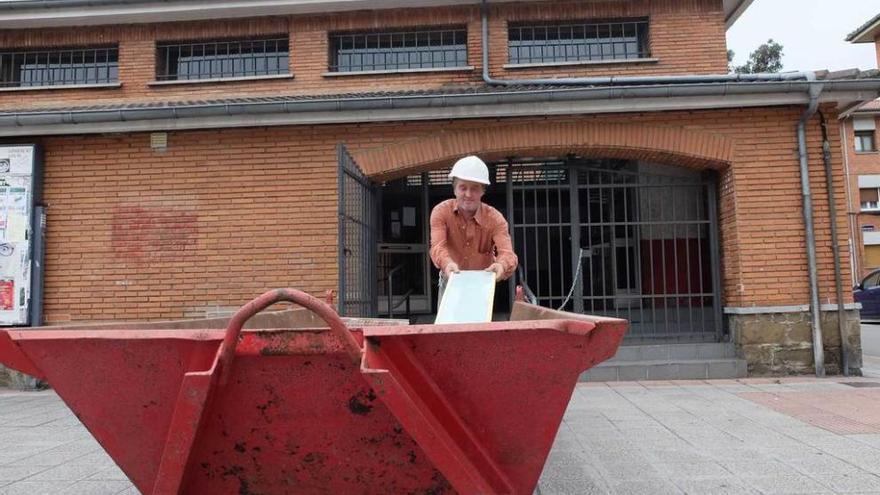 Un operario saca material del local de Santa Marina donde se ubicará el nuevo comedor de Amicos.
