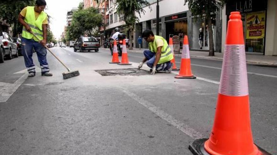 Operarios trabajando en las tapas de alcantarilla de la Alameda.