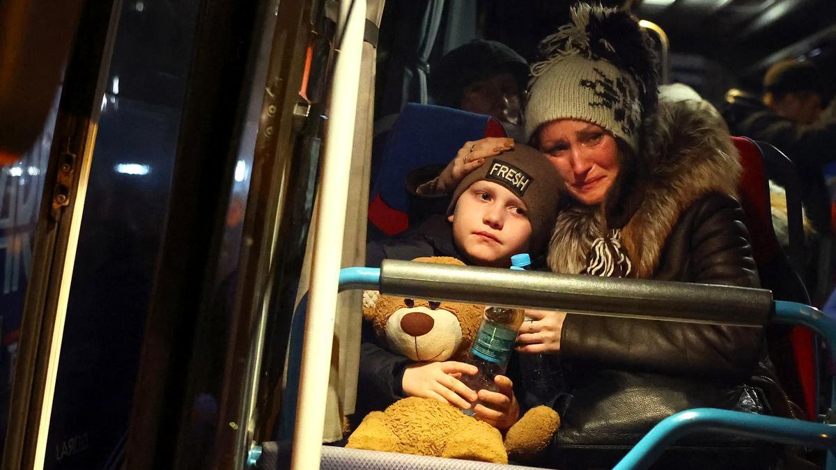 Una refugiada ucraniana junto a su hijo en un autobús para abandonar Ucrania.