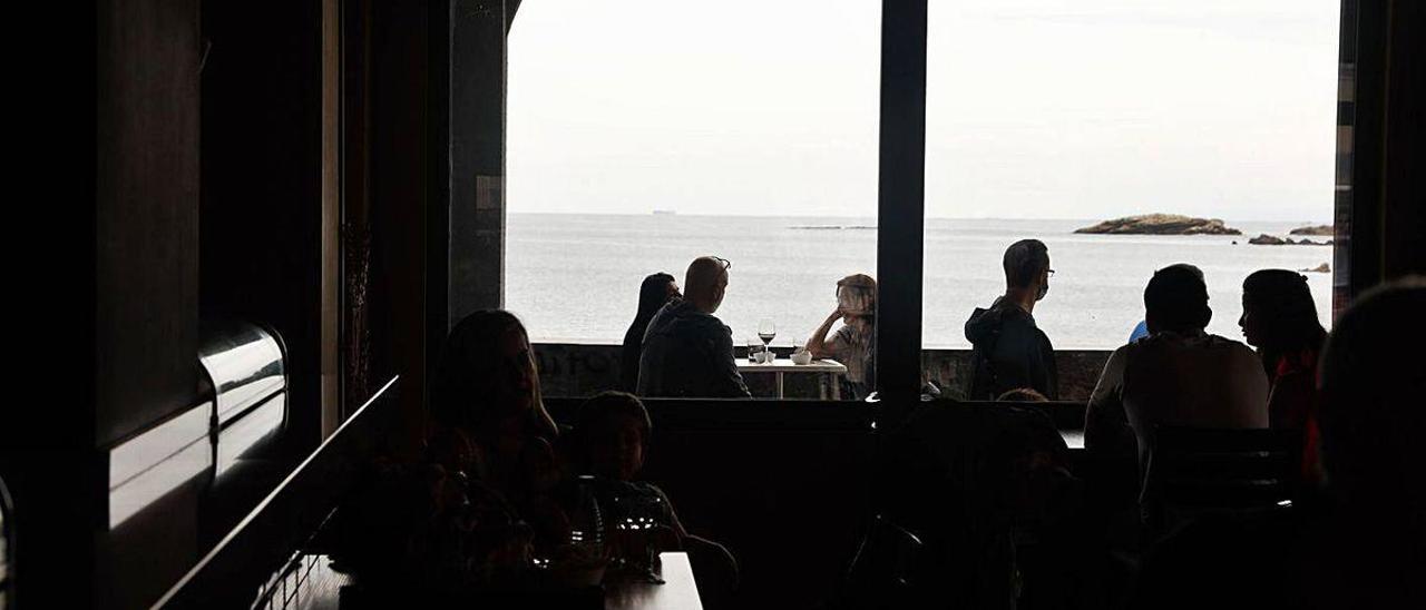 Ambiente en el interior y en la terraza de un local de La Ribera, en Luanco.