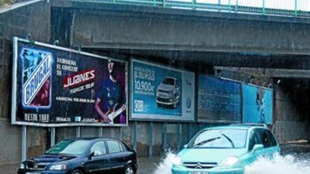 Un coche parado en medio de un puente inundado en L'Hospitalet.